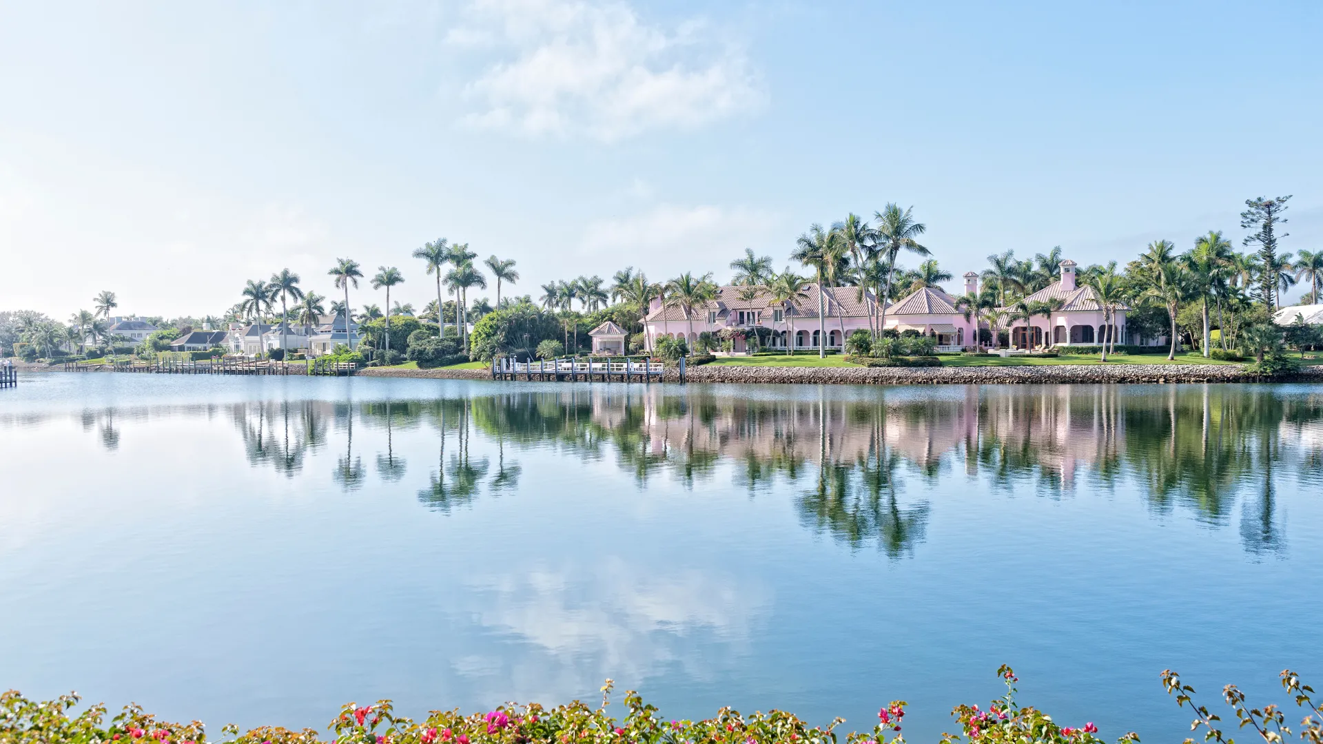 Calm lake with palm trees and California real estate waterfront houses.